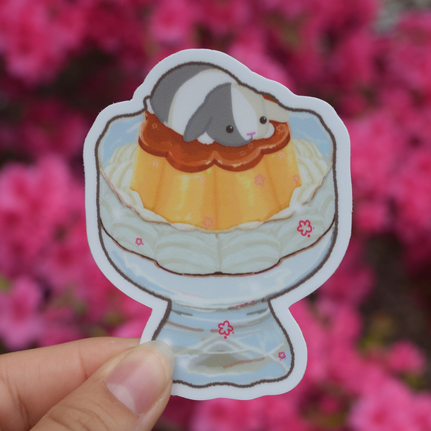 flower shaped flan in a glass cup with whipped cream and a bunny on top