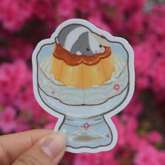 flower shaped flan in a glass cup with whipped cream and a bunny on top